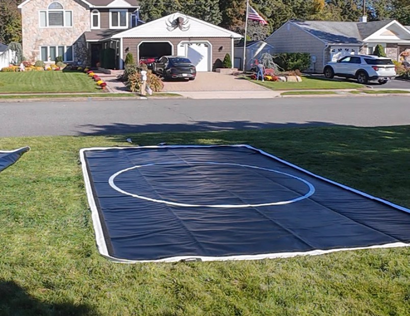 A fully deflated FlowSpace mat lying completely flat on a front lawn