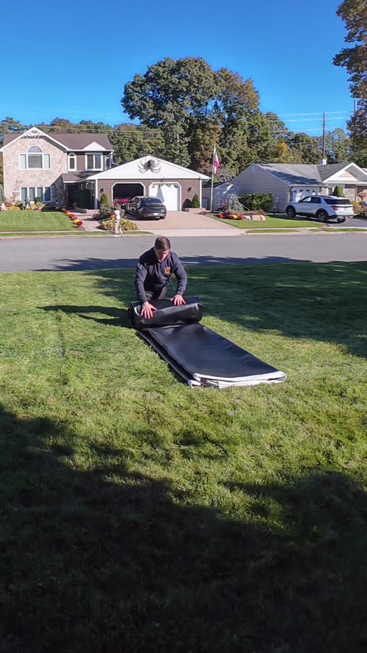 Kneeling on the mat and rolling it up tight, leaning body weight into the roll