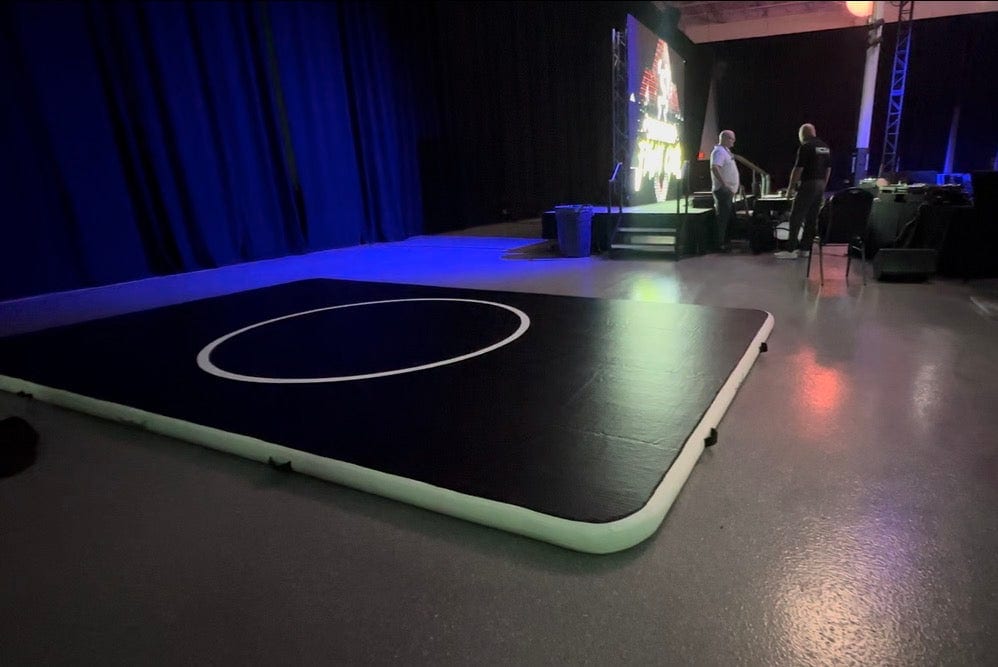 A 10 by 15 Pro FlowMat rolled out on an arena floor in front of a stage