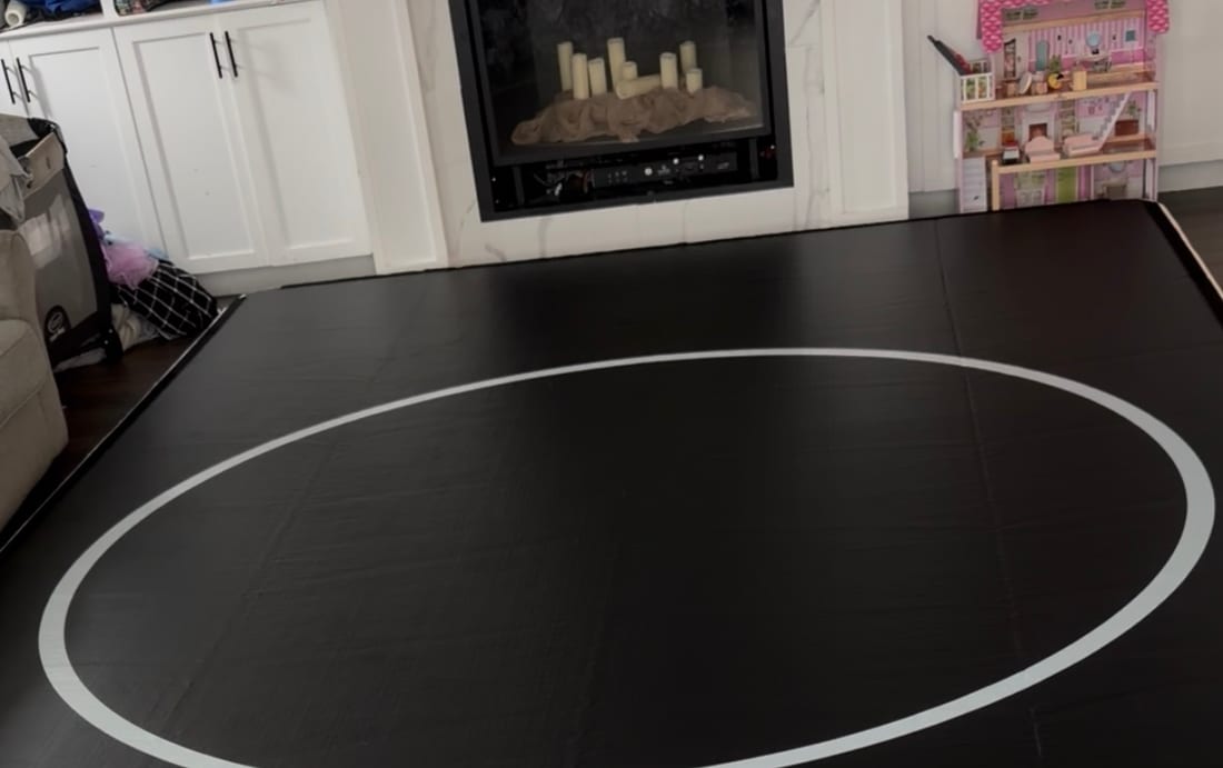 A 10 by 15 Pro FlowMat covering the floor of a family living room, in front of a fireplace and beside a sofa